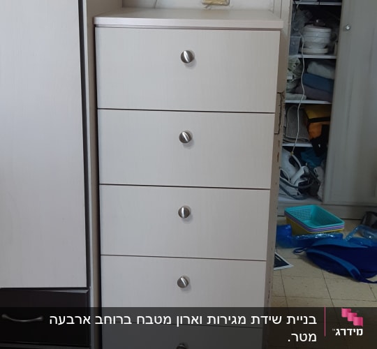 ארון מגירות לבן עם ידיות מתכת במטבח